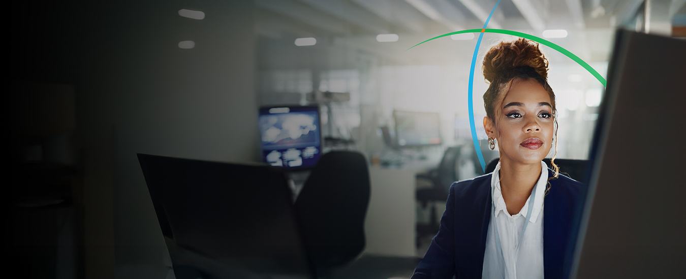 banner showing a business professional looking at a monitor while sitting in a modern workspace
